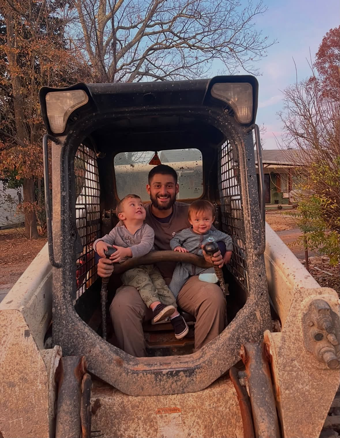 Josh Solano, owner of Southern Style Turf & Design, with his sons in a skid steer