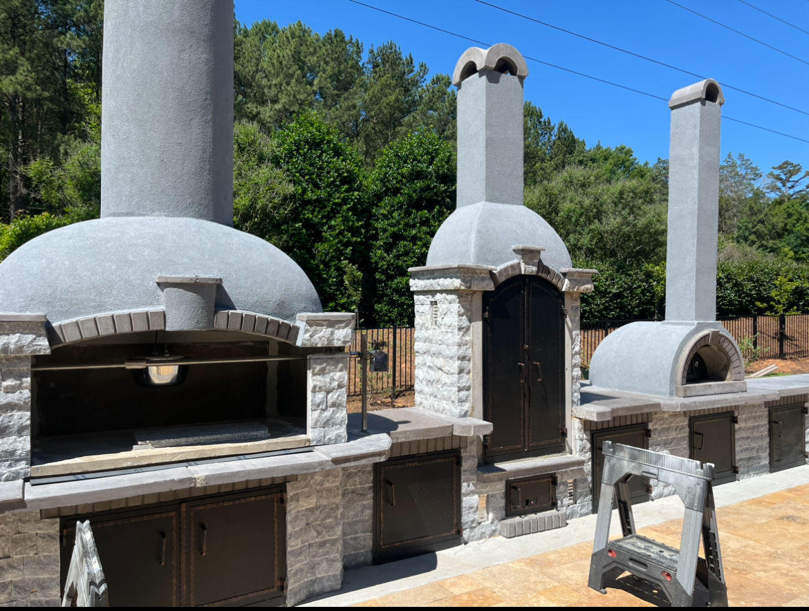 Masonry outdoor kitchen with wood-fired oven, hearth and chimneys on a paver patio, Mooresville NC